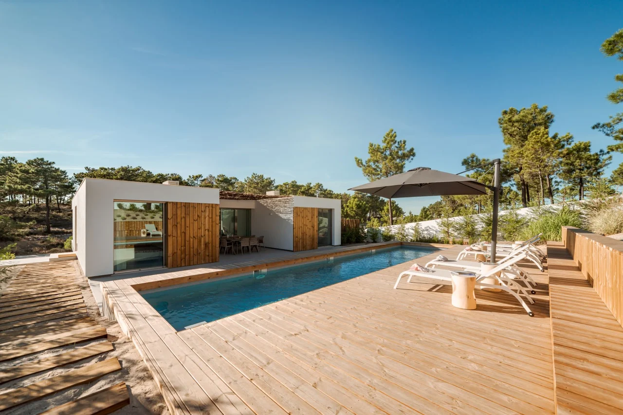 A backyard oasis with a refreshing pool surrounded by a spacious wooden deck